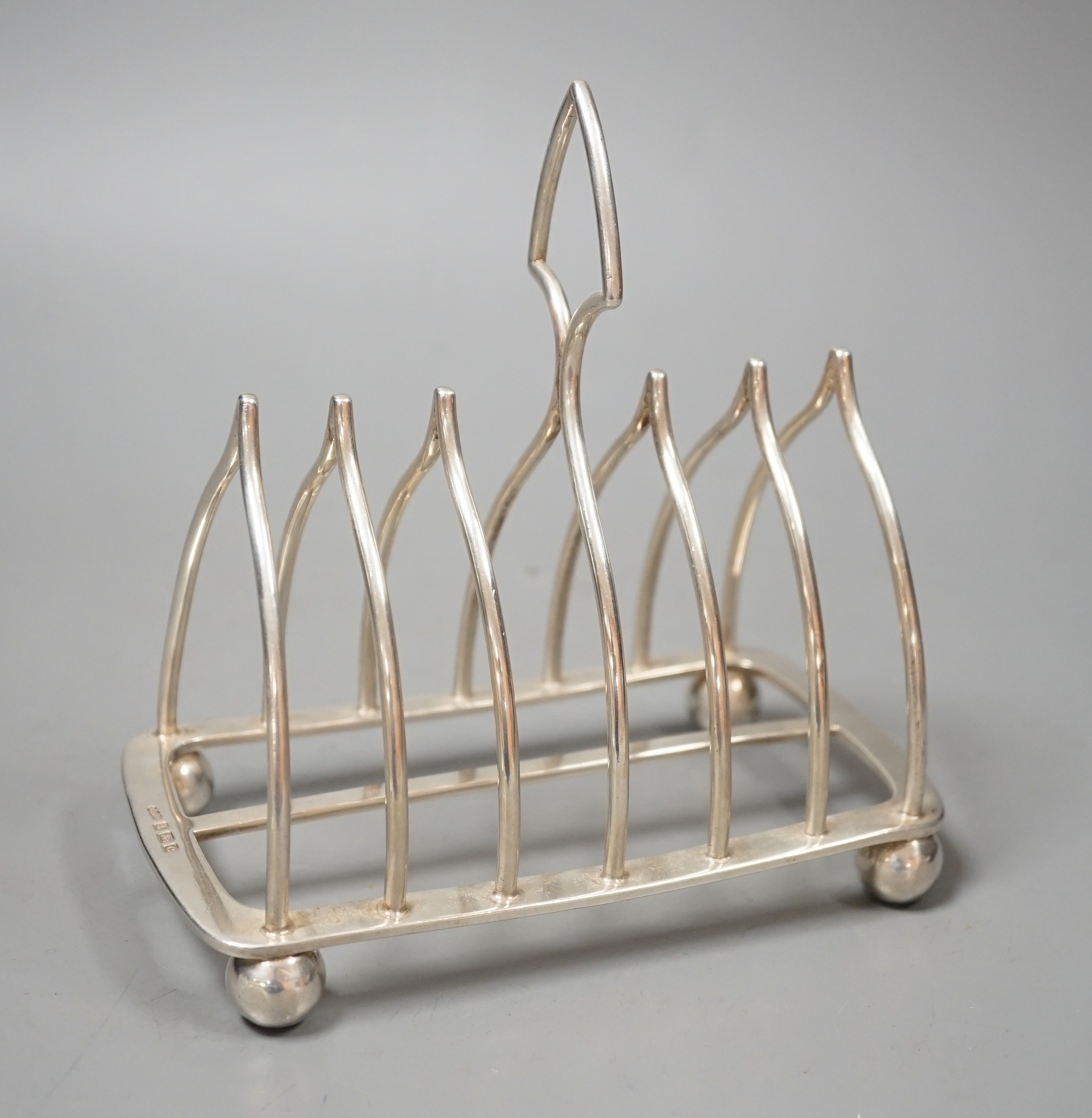 An Edwardian silver eight bar toast rack, on ball feet, by Elkington & Co, Birmingham, 1902, length 15.4cm, 10oz.